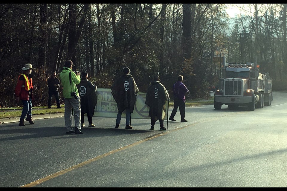 Anti-pipeline protesters stop trucks headed for the Trans Mountain tank farm in Burnaby Friday.