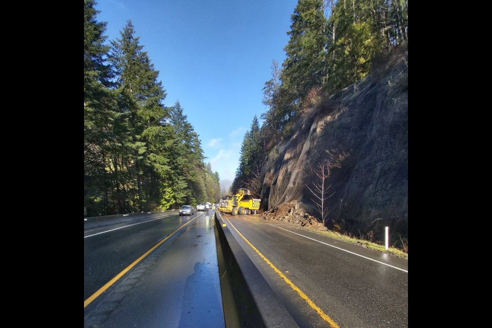 Crews remove rocks and debris from Trans-Canada Highway south of Goldstream Provincial Park as traffic proceeds.