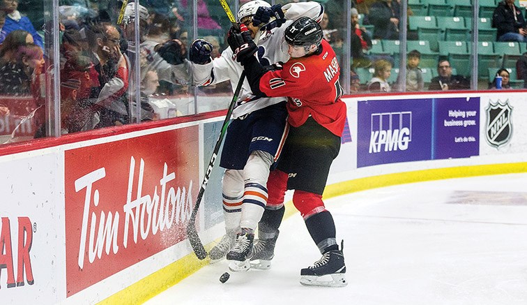 Citizen Photo by James Doyle. Prince George Cougars forward Josh Maser takes a Kamloops Blazers defender into the boards on Saturday night at CN Centre.