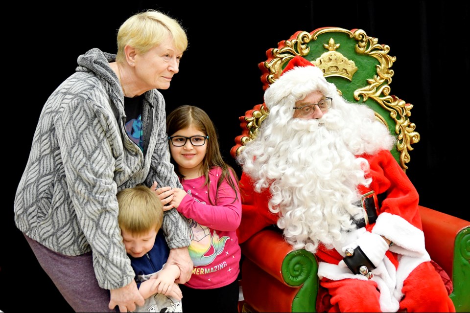 Helena Perry, six-year-old Sophie and three-year-old Cole visit with Santa.