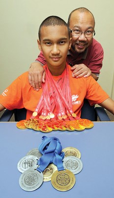 Magnus Batara, with dad, Mario, showing off his medals.