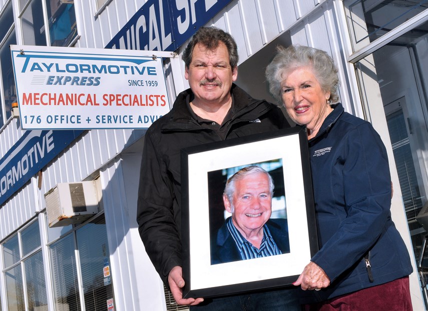 Chuck and Diane Taylor hold a photo of Don Taylor, the founder of Taylormotive. The North Vancouver repair shop is celebrating 60 years in the business. photo Paul McGrath, North Shore News