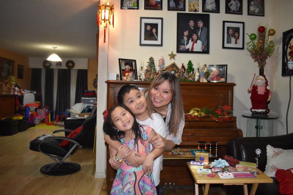 Estella Celeste Banez (on the very left side) with her brother Lazarus and her mum Banez. Estelle is thrilled to throw a party on Dec. 7 and 14. Nono Shen photo