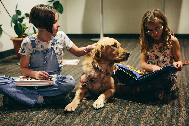 Annie Letheman (left) her sister Ruby read while petting Abby.