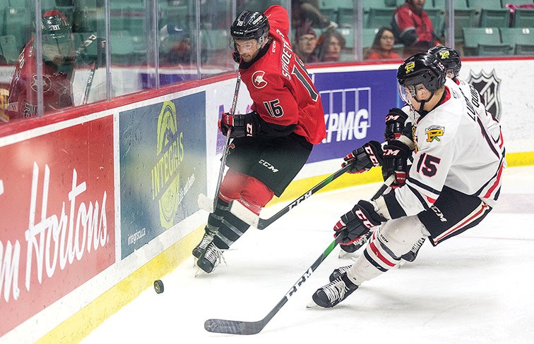 Citizen Photo by James Doyle. Prince George Cougars Ryan Schoettler plays the puck along the boards against a pair of Portland Winterhawks defenders on Wednesday at CN Centre.