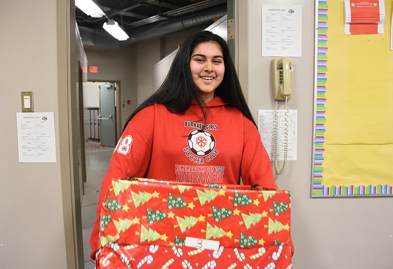 Simran Dutt, a Grade 7 student, carries a box of food into the holiday hamper assembly room at Citadel middle school in Port Coquitlam Dec. 11. The school provided gifts, food and household supplies to eight families this year, including providing $125 gift cards for each family to spend over the holiday season.