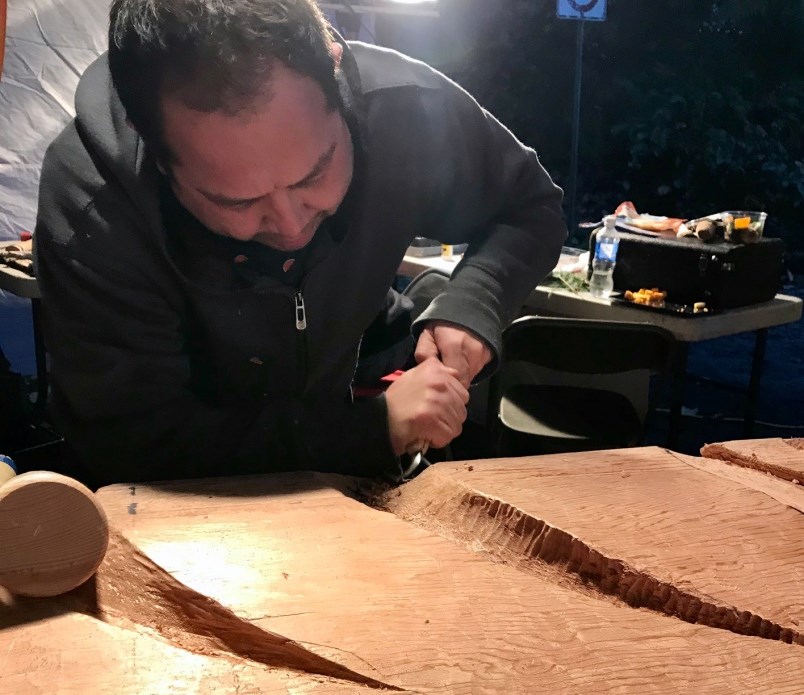 Kwantlen First Nation artist Brandon Gabriel carves Kwikwetlem First Nation symbols into a new house