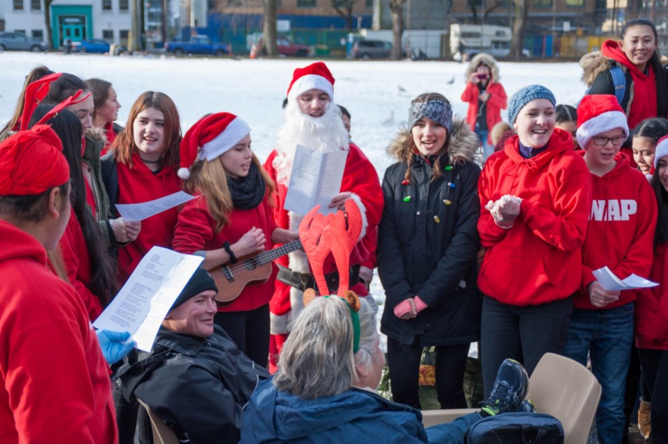 Apolline De Schaetzen plays carols on her ukulele during a visit to Oppenheimer Park before Christma