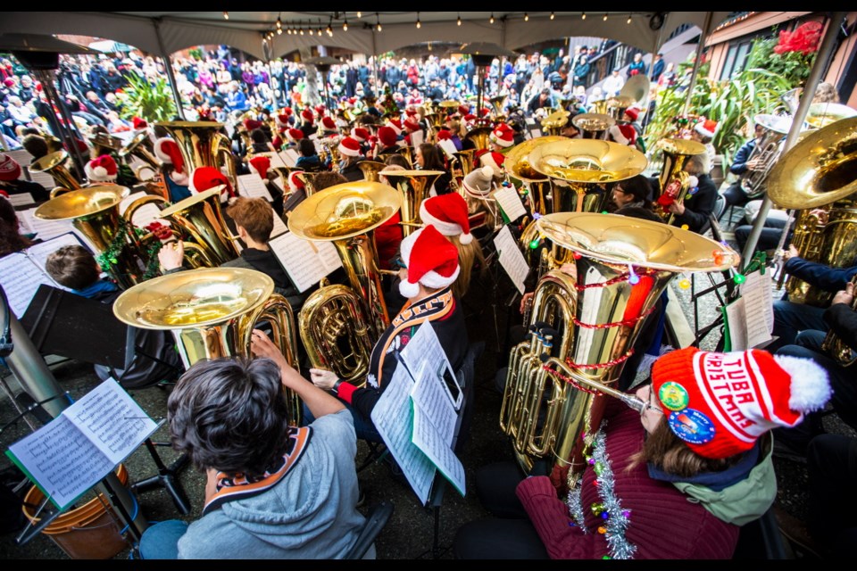 Roxanne van Velzen, right, plays the tuba during Tuba Christmas in Market Square on Saturday. She was among 100-plus musicians performing Christmas carols on low-brass instruments to an enthusiastic crowd. Dec. 14, 2019
