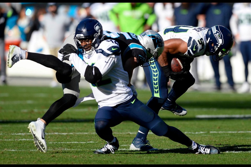 Seattle Seahawks middle linebacker Bobby Wagner (54) intercepts a pass intended for Carolina Panthers wide receiver Chris Hogan (15) as defensive back Lano Hill (42) blocks him during the first half at Bank of America Stadium on Sunday.