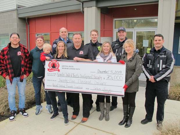 Members of the Delta Firefighters Charitable Society present a cheque for $25,000 to Reach Child & Youth Development Society.