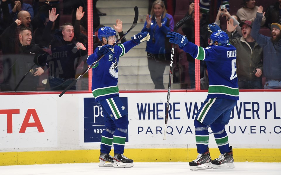 Elias Pettersson and Brock Boeser celebrate a goal for the Vancouver Canucks.