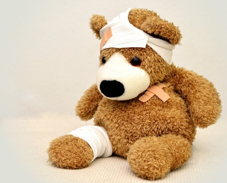 Bandaged teddybear against a white background.