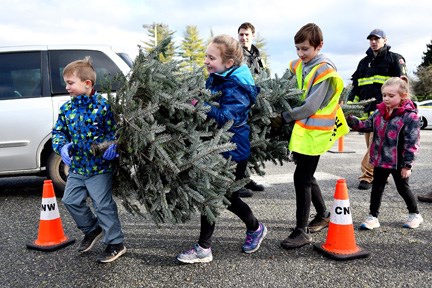 New Westminster firefighters got a little help from Danika Tyler, Dion Tyler, Jake Gardiner and Alexa Tyler on the weekend. The kids helped carry a tree to the chipper during the annual New Westminster Firefighters’ Charitable Society tree chipping event.