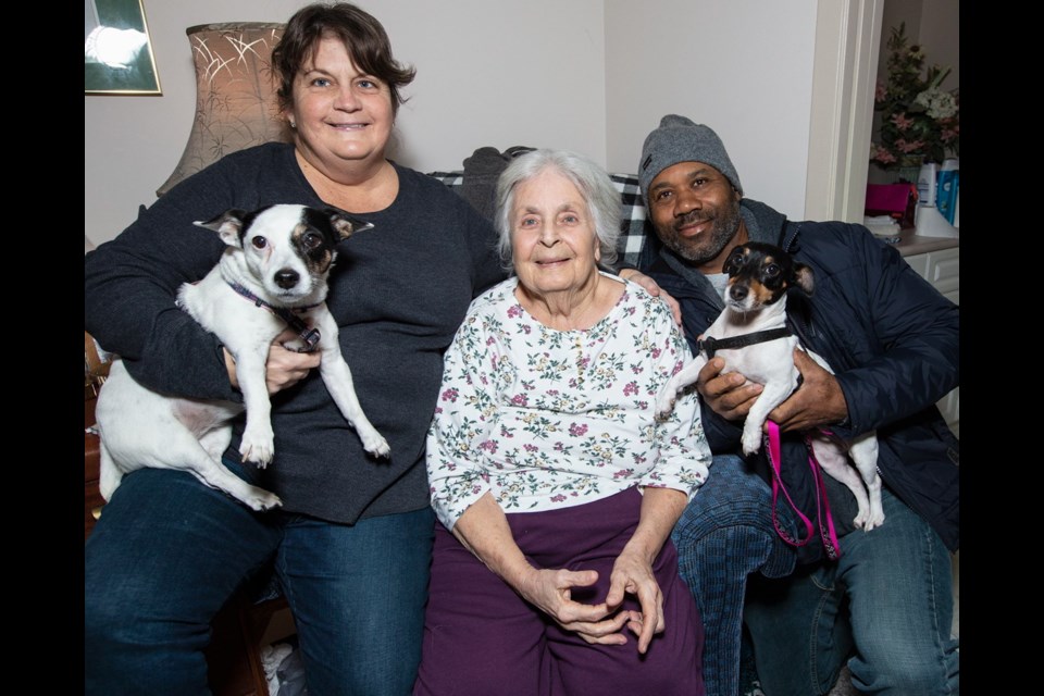 Hurricane survivors Virginia Mosvold, centre, and Sissel and George Johnson, with dogs Sophie, left, and Millie that stayed in the couple’s attic.