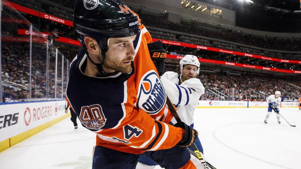 Zack Kassian plays the puck along the boards.