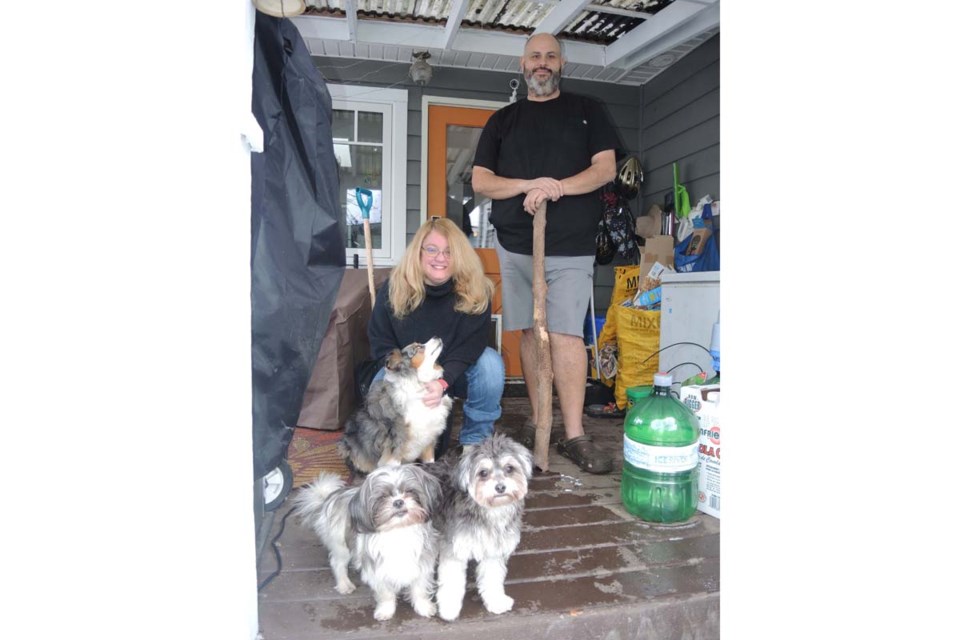 Leanne Taylor and Shane Alexander, with their three dogs which were attacked on this patio last week by a family of four raccoons. Alan Campbell photo