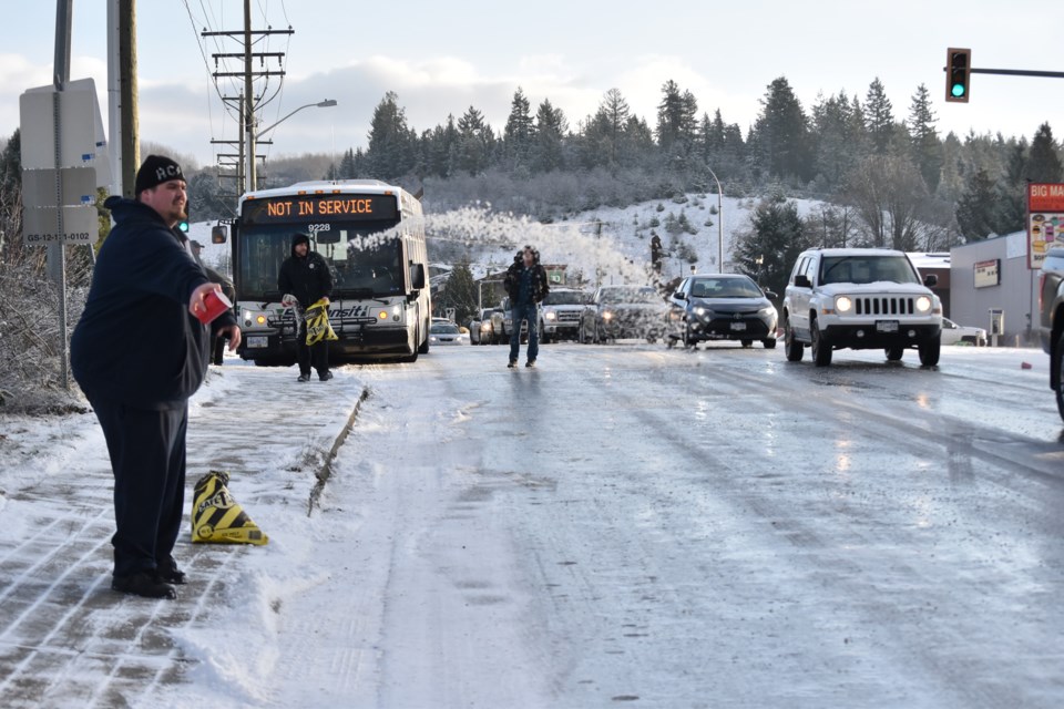 Volunteers from the local NAPA Auto Parts store grabbed bags of salt and got to work on a slippery section of Highway 101 in Sechelt Friday morning just before road crews arrived.