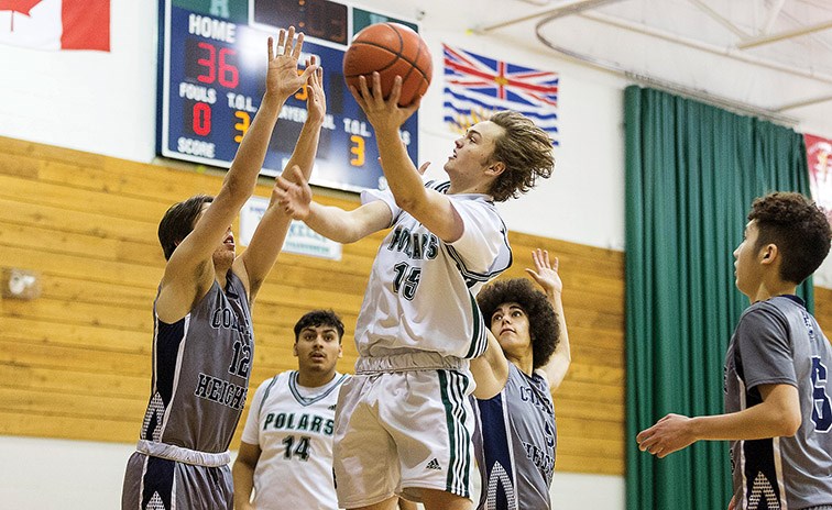 Citizen Photo by James Doyle. PGSS Polars player Jordan Foster goes for a lay-up against College Heights Cougars defender Darian Maurits on Friday evening at Kelly Road Secondary School gymnasium during the Kelly Road Sr. Boys basketball tournament.