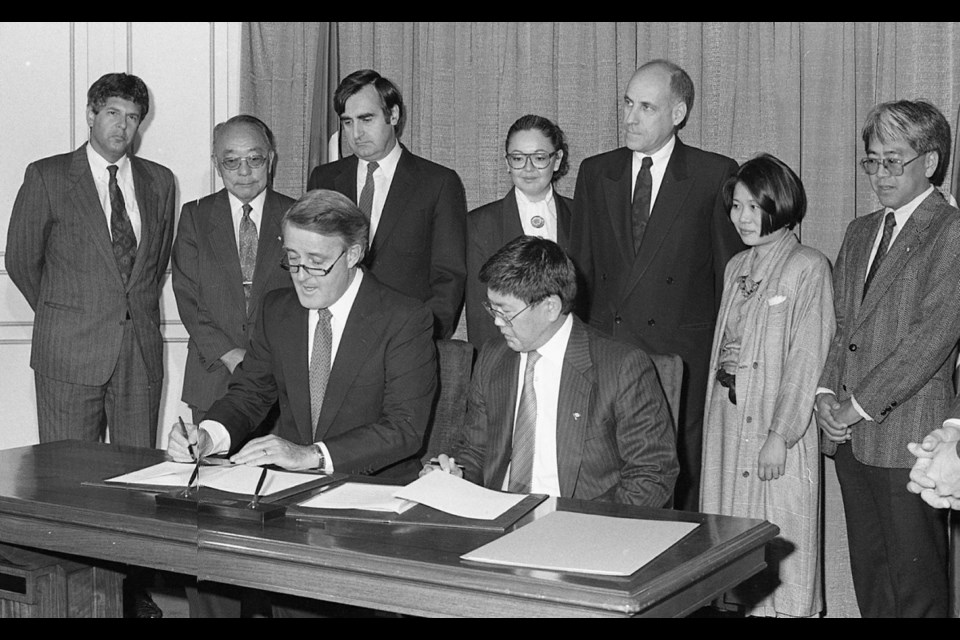 Then-prime minister Brian Mulroney and Art Miki, president of the National Association of Japanese Canadians, sign a redress agreement in 1988 for the internment of Japanese Canadians and the government&Iacute;s theft of their property during the Second World War. Courtesy Nikkei National Museum, 2010.32.27