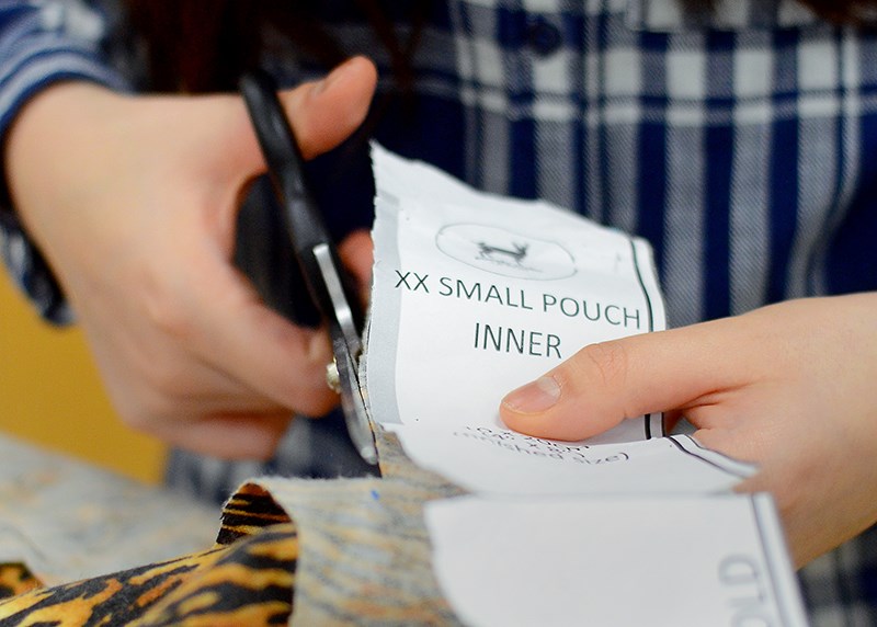 A Burnaby Mountain Secondary School student cuts out a small pouch using a pattern designed by the Australian Animal Rescue Craft Guild.