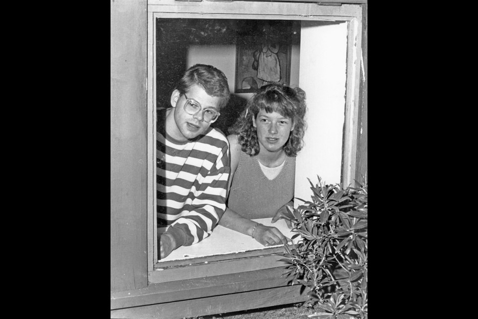 Denise Mueller and her brother Gordon stand at the window of their James Bay suite where a cougar crashed through and into Denise&ecirc;s bedroom. Times Colonist file photo