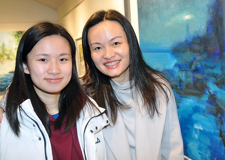 Dina Feng and mom Macy Li with Geoffrey Feng’s painting Lighthouse.