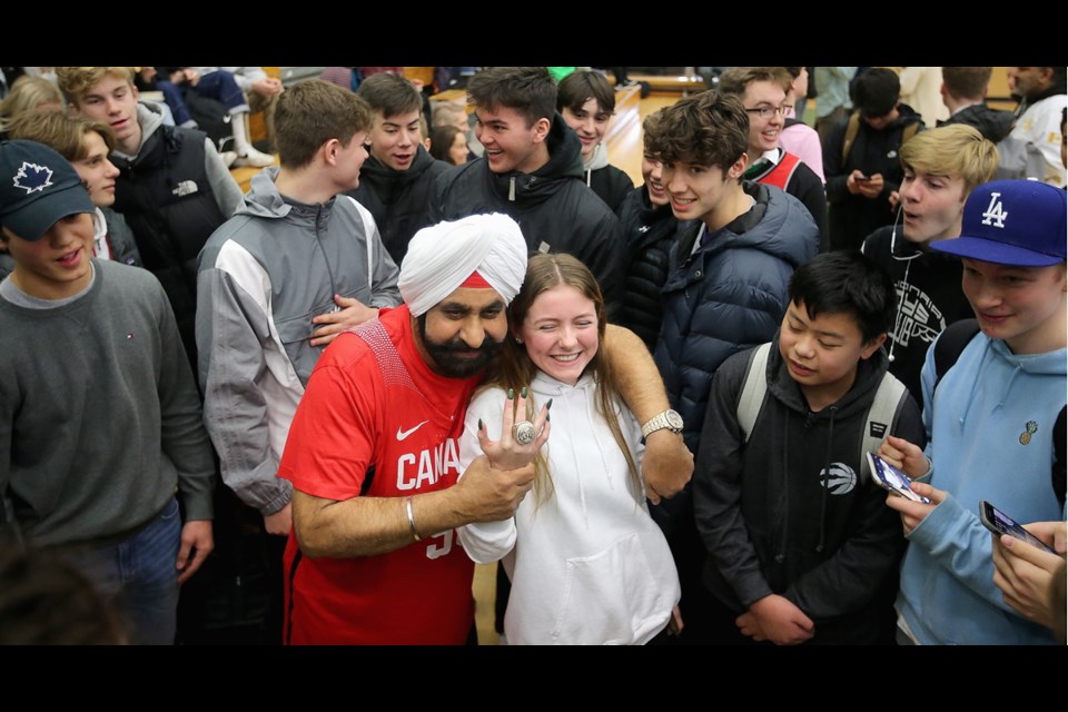 Toronto Raptors Super Fan Nav Bhatia is surrounded by Oak Bay High basketball enthusiasts as Grade 11 student Ella Brown shows off his Raptors 2019 NBA championship ring. Bhatia was at the school on Thursday for a ceremony promoting the Olympic basketball qualifying tournament to be held in Victoria in June. Jan. 30, 2020