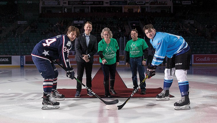 Citizen Photo by James Doyle. From left, Tri-City Americans captain Sasha Mutala, RE/MAX Centre City Realty owner Zach Mills, Noreen Woodford, Rick Woodford, and Prince George Cougars captain Josh Maser take part in a ceremonial face-off for WHL Suits Up to Promote Organ Donation on Friday night at CN Centre. The jerseys the Cougars were wearing will be auctioned off with proceeds going to the Kidney Foundation of Canada.