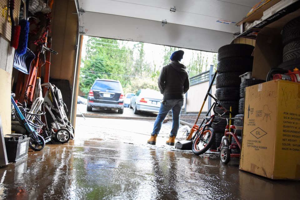 Carlos Manahan's brother looks out from a garage that, only hours early, was a metre deep in water.