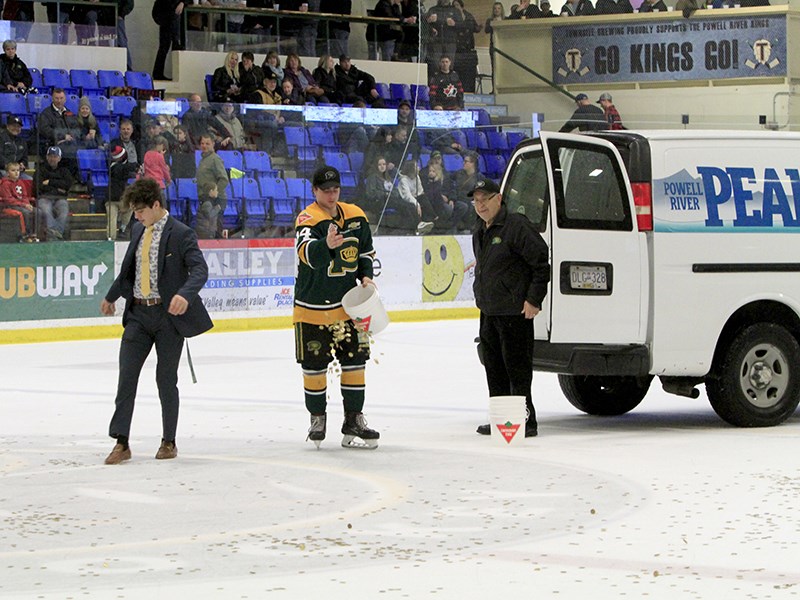 Powell River Kings' volunteer Joe Mastrodonato [right] delivered $10,000 worth of loonies to Hap Parker Arena on Friday, January 31, and had help from two players to spread them between the bluelines. Alicia Baas photo