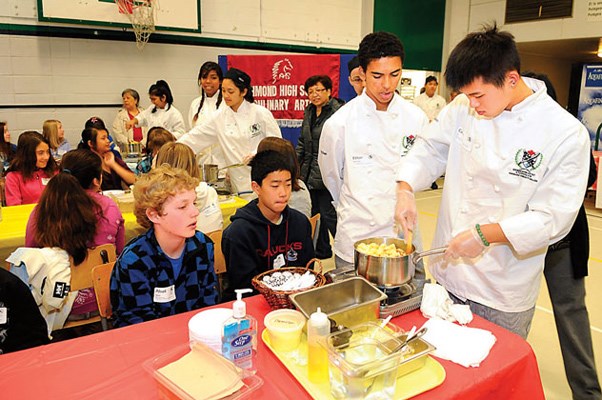 Ethan Saimoici (left) and Calvin Yu from Richmond High School's cooking apprenticeship program stir up a pasta dish.
