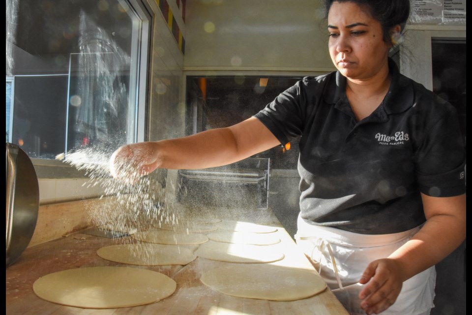 Rizwana Syed prepares pizza crust at Me-n-Ed's in Coquitlam.