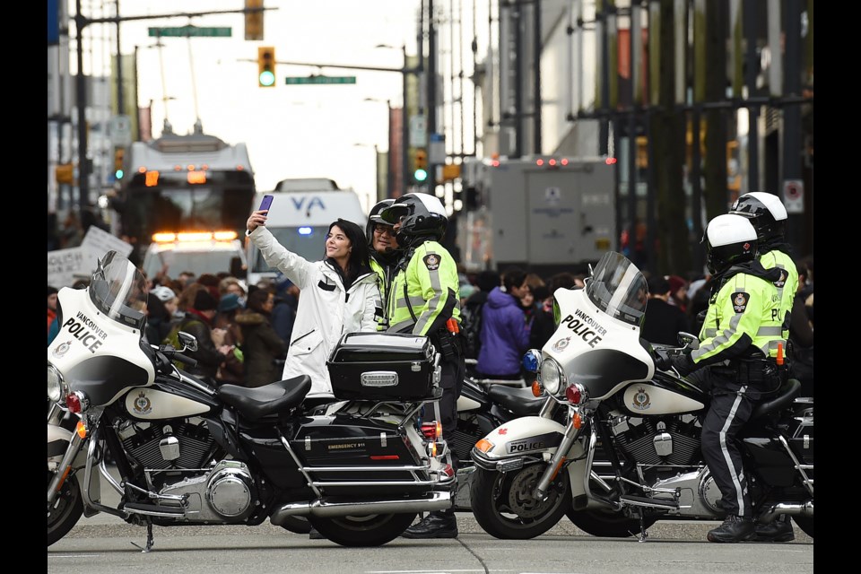 Police offers pose for selfies while protesters in solidarity with the Wet’suwet’en gathered downtown for another day of action. Photo Dan Toulgoet
