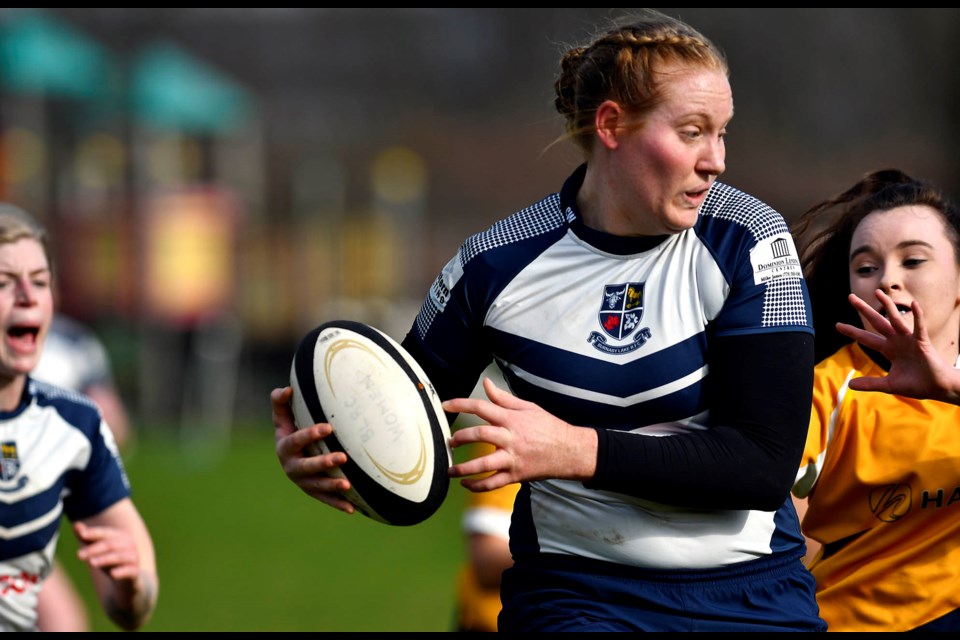 Burnaby Lake captain Emily Van Gulik, centre, looks to break away from a Scribes defender during Saturday’s Div. 1 women’s rugby game in Burnaby.