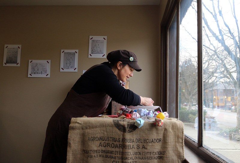 Margaret Inoue sets up a display in the window of her small-batch chocolate shop, Cocoaro, on Port Moody's Clarke Street.