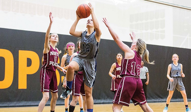 Citizen Photo by James Doyle. College Heights Cougars player Olivia Vigue goes for a lay-up against the North Peace Grizzlies on Friday evening at Duchess Park gymnasium during the championship game of the 2020 North Central Zone Junior Girls Girls Basketball Championships.