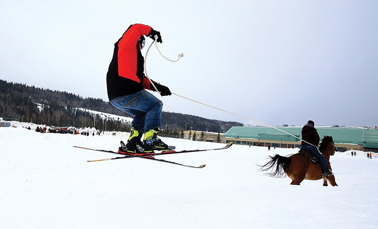 A skier catches some air while being pulled by a horse and rider on Sunday morning at the Prince George Rodeo Grounds for the second annual Skijoring PG event.