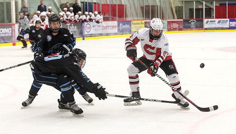 Citizen Photo by James Doyle. Cariboo Cougars forward Jaydon Merritt goes after the bouncing puck against a pair of Kootenay Ice defenders on Saturday afternoon at Kin 1.