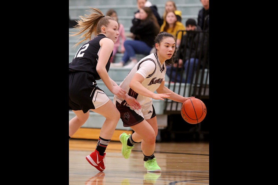 Jenna Griffin, of the Heritage Woods Kodiaks, drives around Terry Fox Ravens defender Taylor Mathews in the first half of their Fraser Valley North semifinal game, last Thursday at Gleneagle secondary school in Coquitlam. Fox won, 76-66, and went on to upset the Riverside Rapids in the zone championship final, 92-89. Both teams qualify for the provincial AAAA championships, which begin Feb. 26 at the Langley Events Centre. The Kodiaks, meanwhile, will have to win its way into the provincial tournament in a last-chance game against North Surrey secondary after being upset by the Burnaby South Rebels, 64-60, to determine the third qualifier from Fraser Valley North.
