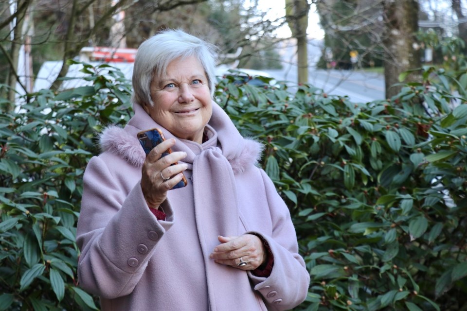 Jude Neale stands in front of a bush with a phone in hand