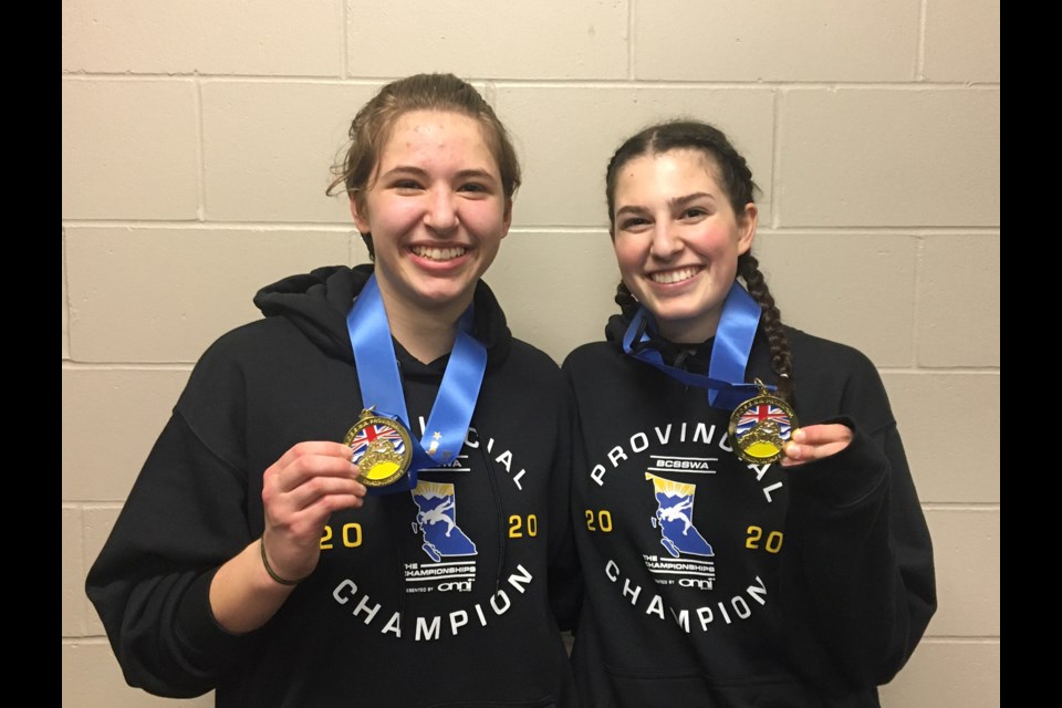 St. Thomas More medalists Logan Stimson, at left, and Clara Scaglione celebrate their championship gold wins at last week's B.C. Secondary Schools wrestling championships in Langley.