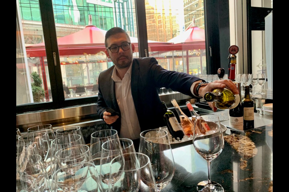 Sommelier Jason Yamasaki pouring wine at the festival opening.