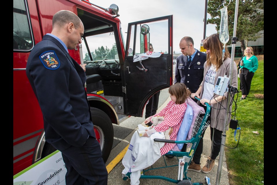 Danielle Green and her daughter, Lucy Spillett, 7, check out a fire truck with firefighters Brian Swanson, left, and Jason Ahokas after the Victoria Hospitals Foundation accepted a cheque for $25,000 from the Professional Firefighters of Greater Victoria Charitable Foundation as part of their $250,000 pledge supporting pediatric care at Victoria General Hospital.