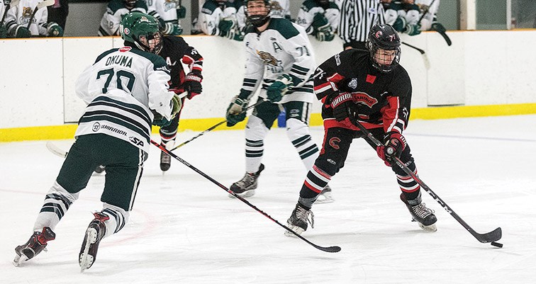 Citizen Photo by James Doyle. Cariboo Minor Midget Cougars forward Brady McIsaac looks to make a play with the puck against North Island Silvertips defender Kevin Okuma on Saturday evening at Kin 2 in the second game of their best-of-three playoff series.