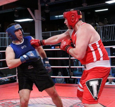 Burnaby's Tyson Papalia, in blue, dodges a punch from Jeremy Kouwenhaven during the B.C. 91+ open elite men's division final in Richmond last month.