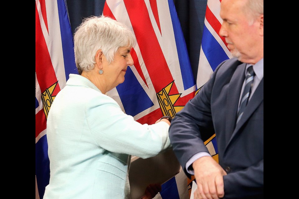 Finance Minster Carole James and Premier John Horgan greet each other with an elbow at news conference at the legislature. March 17, 2020
