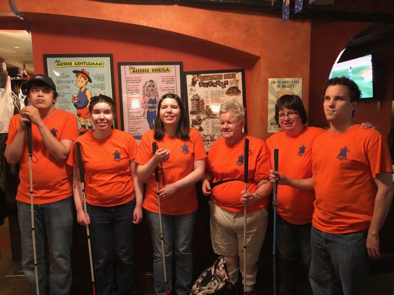 Board of directors posing in orange staff shirts with Camp Bowen logo on left breast.
