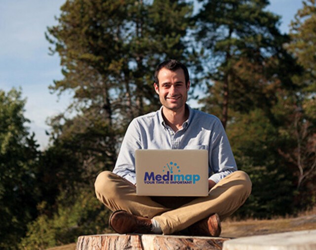 Man in forest with a laptop with Medimap logo