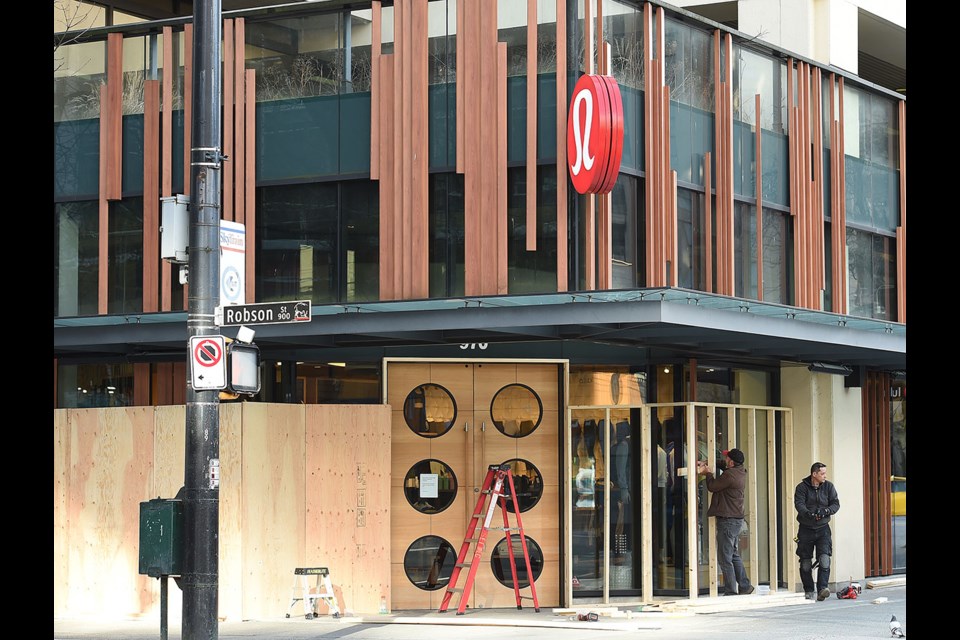 A Courier report watched as the Lululemon store on Robson was boarded up Tuesday. Photo Dan Toulgoet